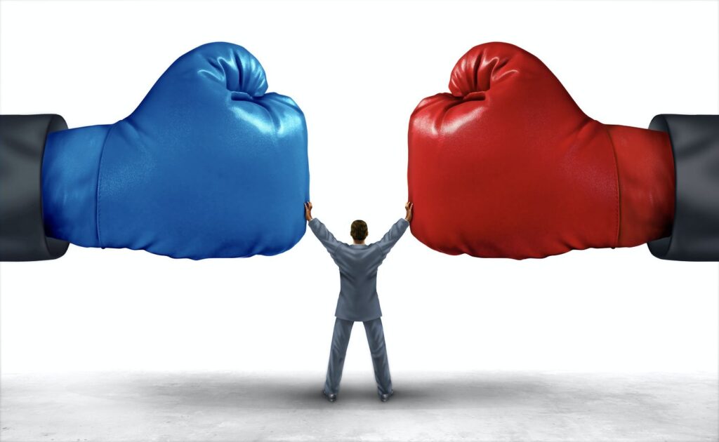 Red and blue boxing gloves held apart by person.